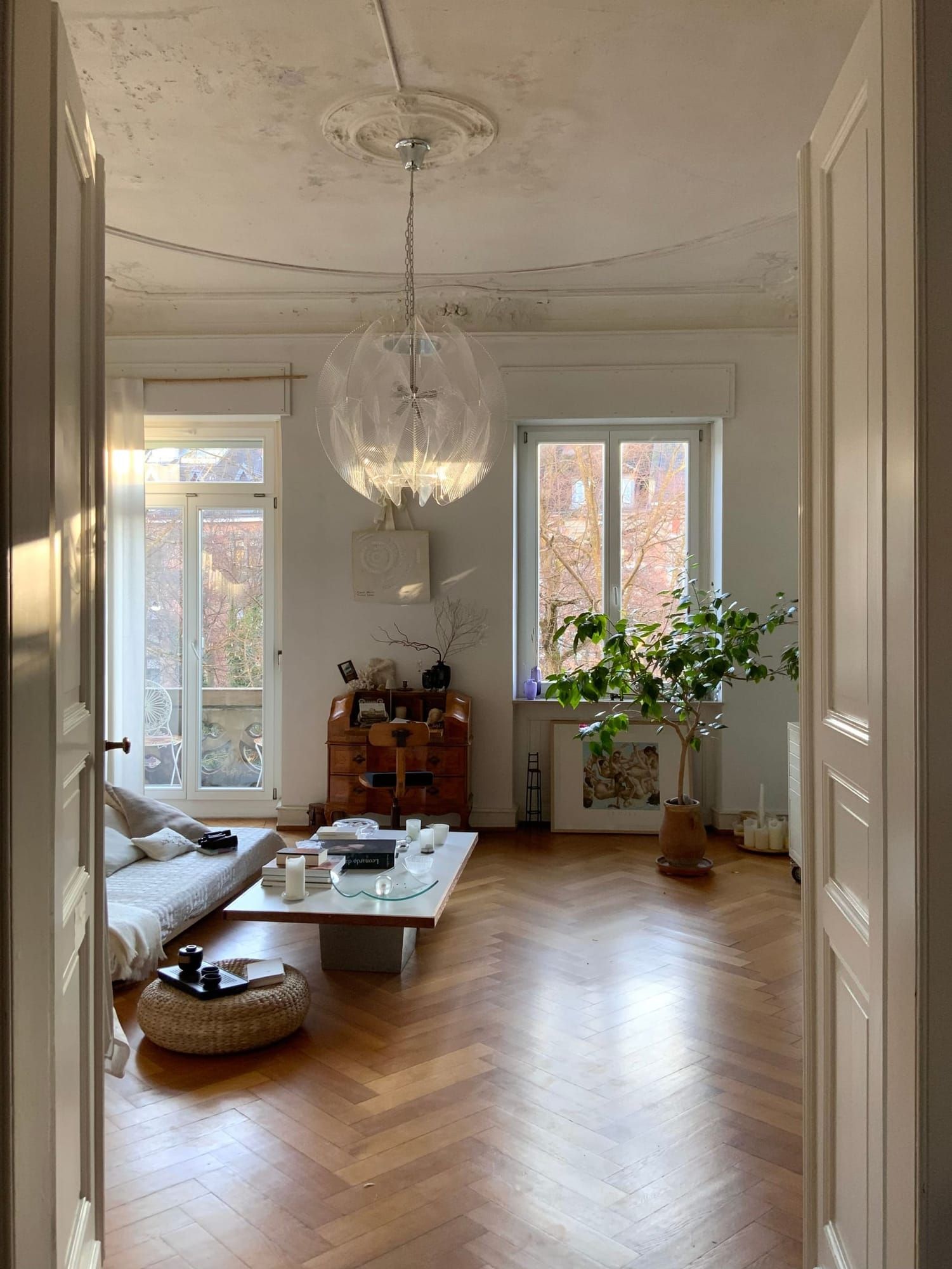 Wohnzimmer mit Flügeltüren, Pflanzen und Parkett